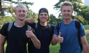 Three students with thumbs up