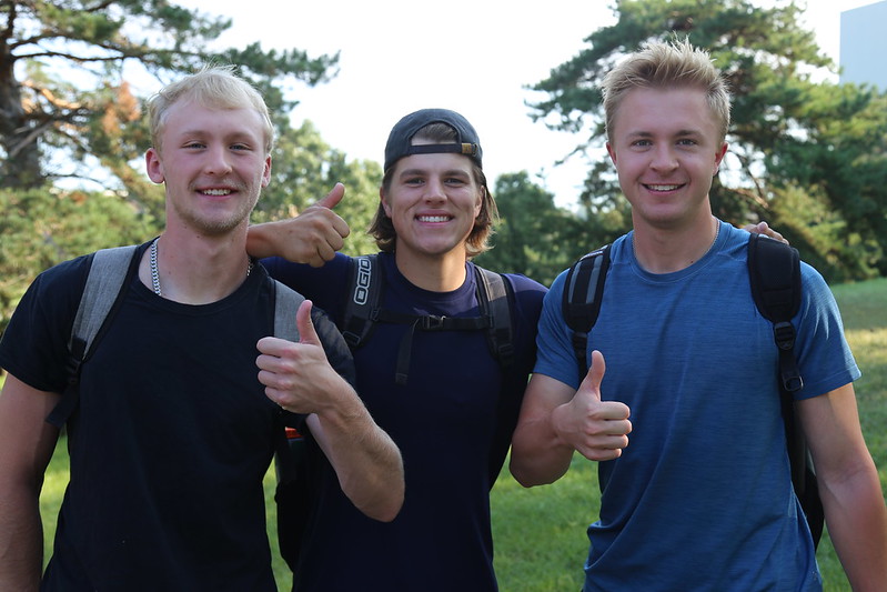 Three students with thumbs up