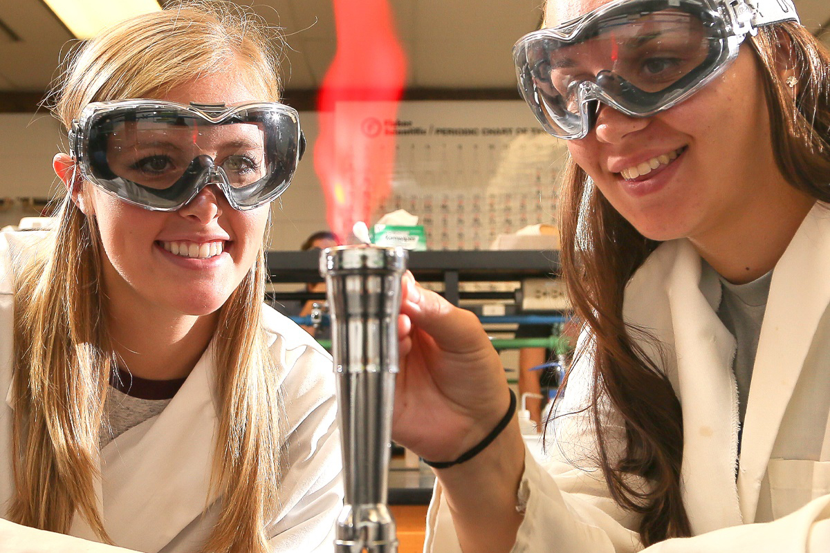 Two students using flame in STEM program