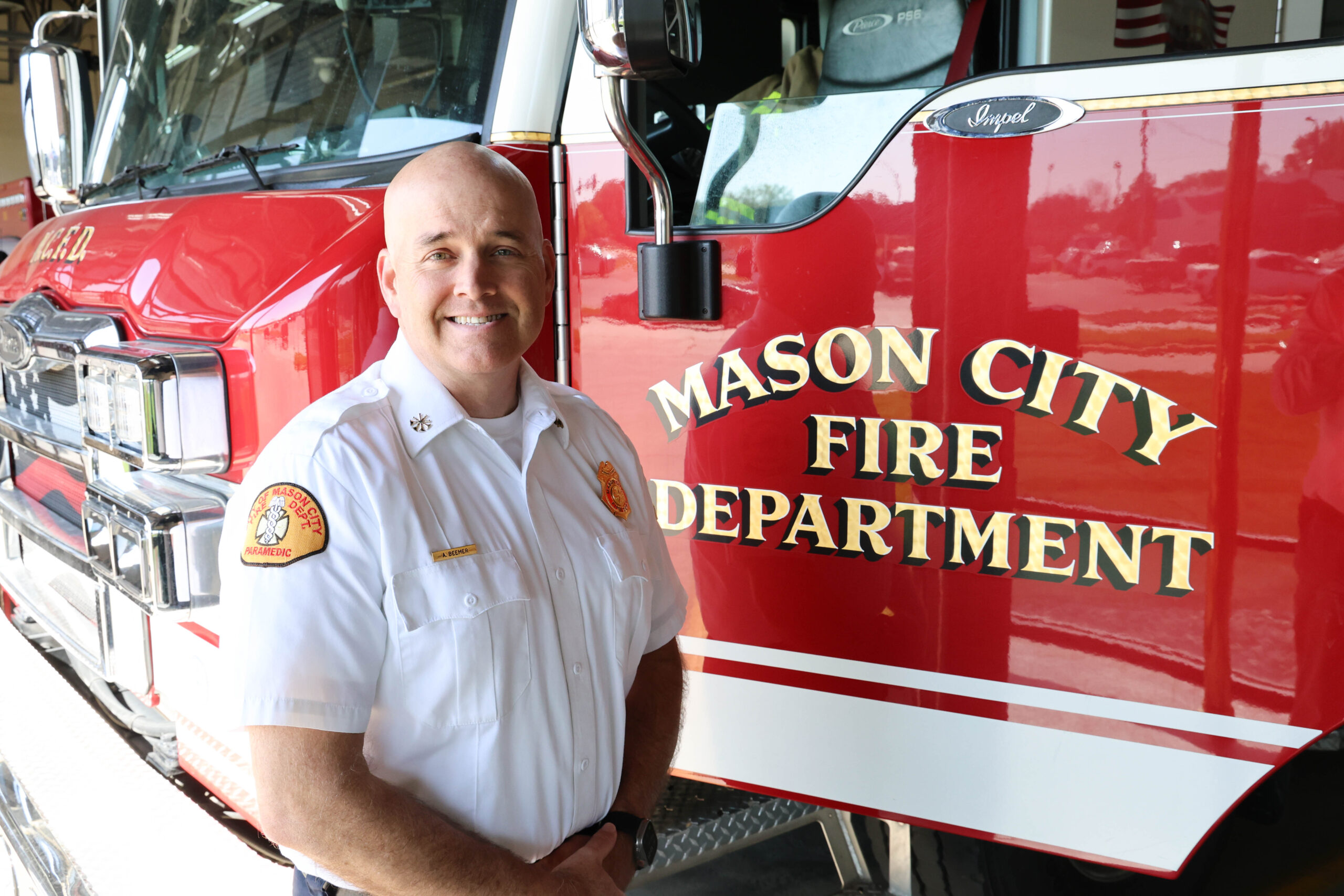Aaron Beemer stands next to a fire engine
