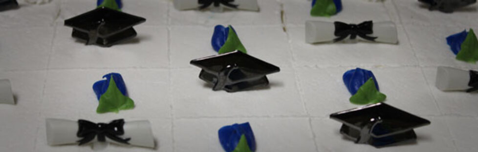 Photo of Graduation Cake decorated with caps and scrolls.
