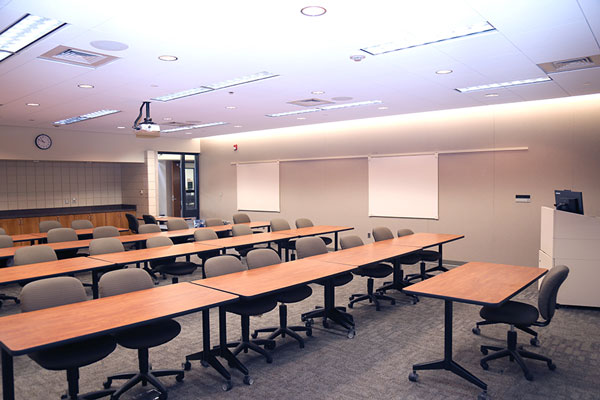 Photo of meeting room PC117 showing tables, desks, projector and command station