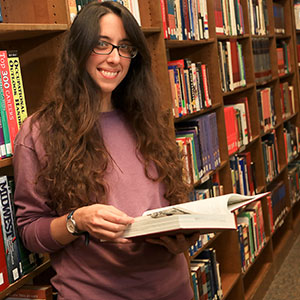 Photo of female NIACC student reading a book in the Library