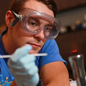 Photo of Male NIACC student wearing goggles, working with scientific instruments