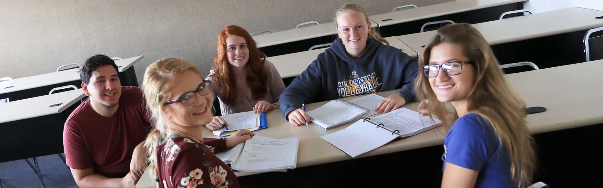 Students sitting around a table working on paperwork