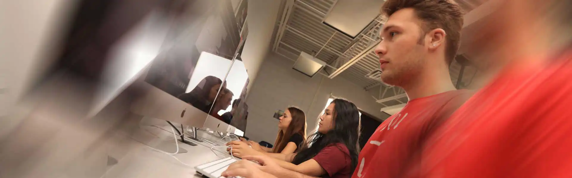 Students sitting at table working on computers