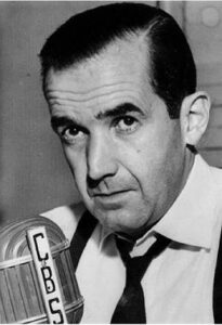 Edward Murrow: Black and white photo of a man wearing a white button up shirt with a black tie and suspenders. 