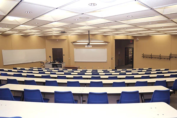 Photo of meeting room MH104G showing projector, white boards, and command station