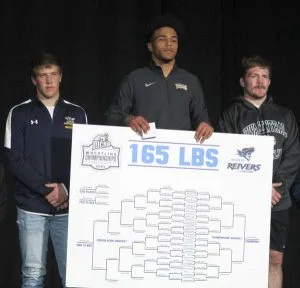 Picture of Wrestling Champion Christian Minto holding 165 pound bracket